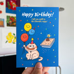 Birthday card with cartoon cat and balloons held by a hand