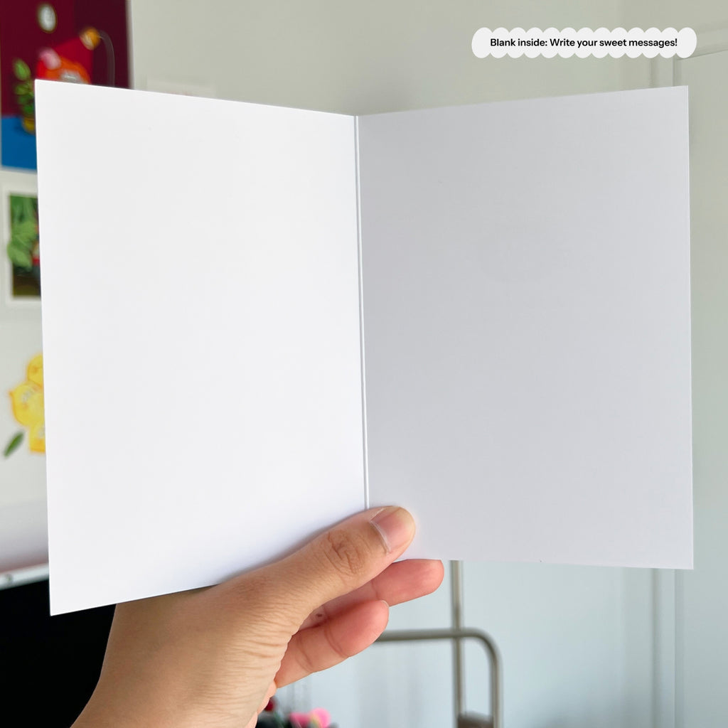 Hand holding a white card with a blurred background