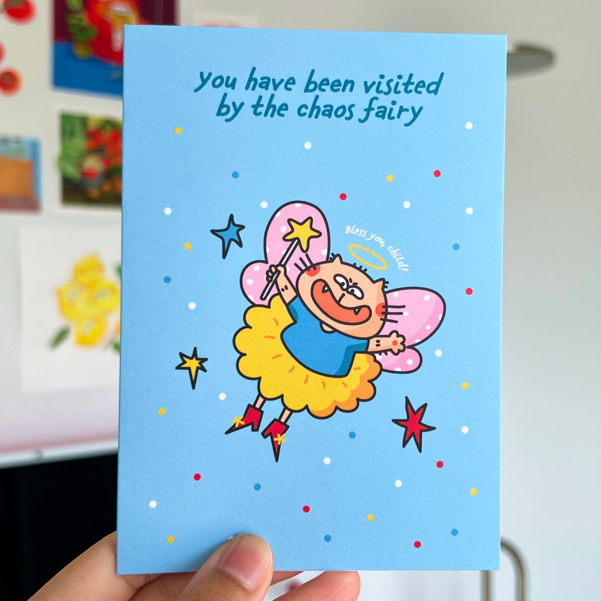 Card with a cartoon cat fairy character and text 'you have been visited by the chaos fairy' on a blue background.