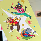 Colorful illustration of three cartoon cats on a yellow background with stars.