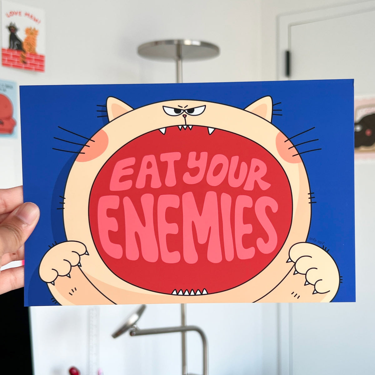 Cartoon character with a sign that reads 'Eat Your Enemies' text on a blue background