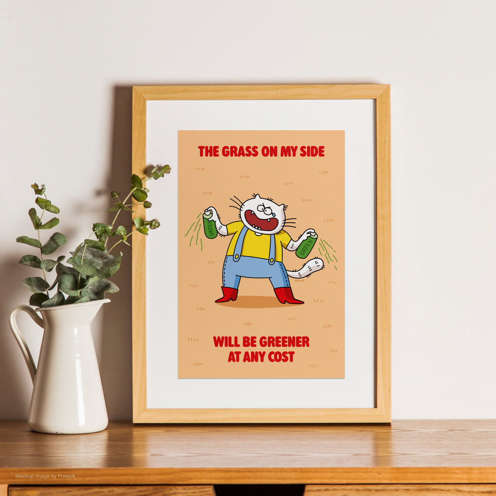 Framed cartoon cat print with a character and text on a wooden shelf with a plant.