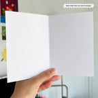 Hand holding a white card with a blurred background