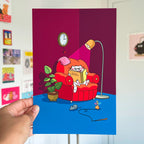 Cartoon cat on a red chair with a book, held up against a colorful wall.