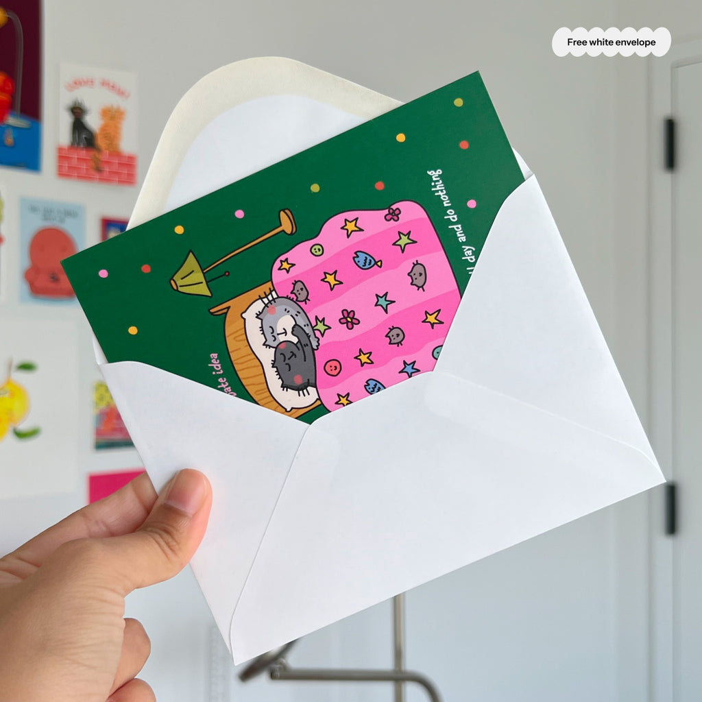 Hand holding a card with a cat illustration and a white envelope.