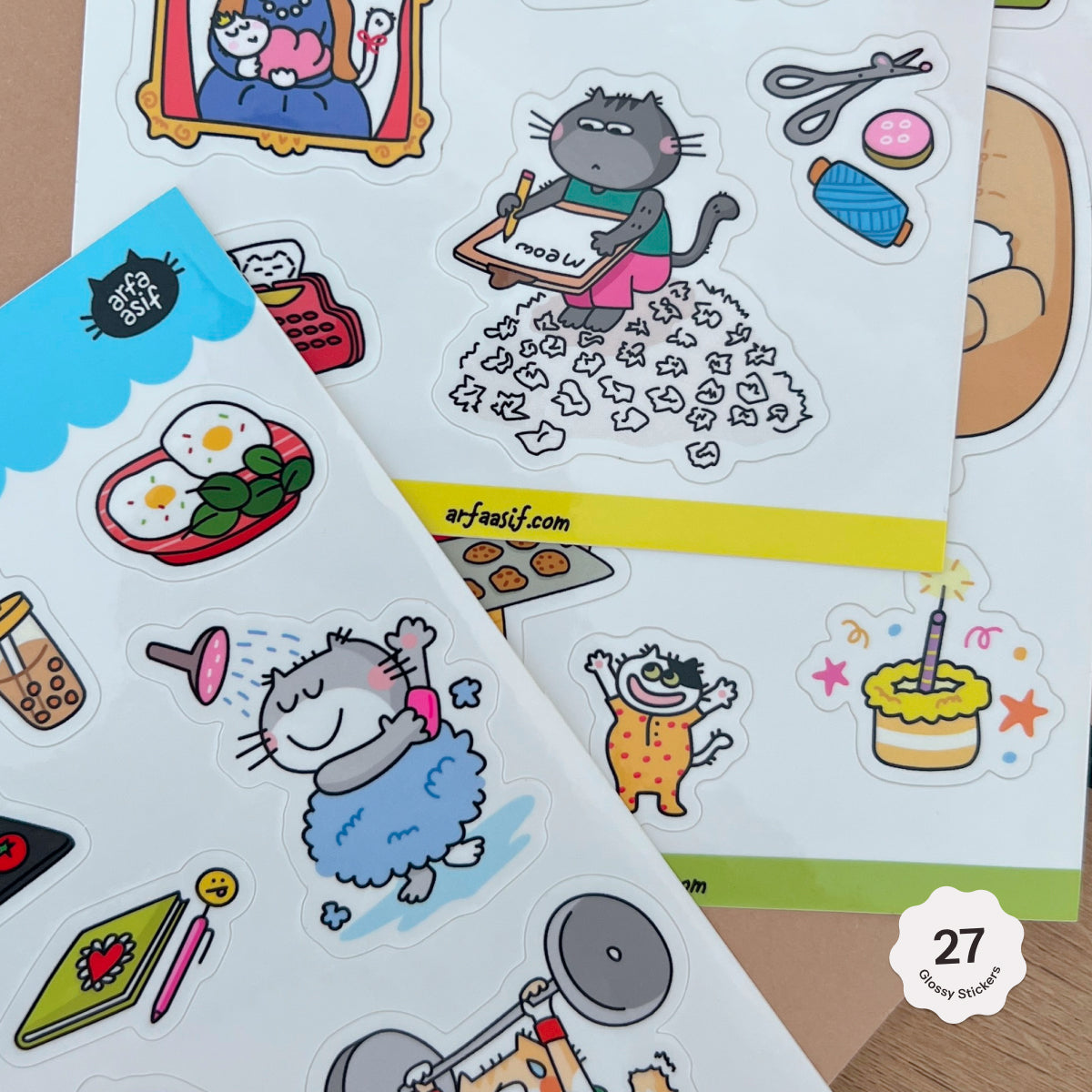 Sticker sheets with fun cat characters on a wooden surface