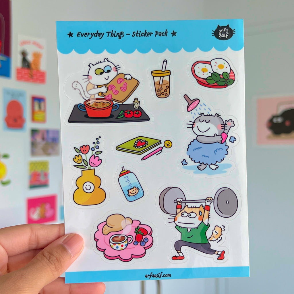 Sticker pack with cat illustrations held by a hand against a colorful background