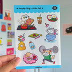 Sticker pack with cat illustrations held by a hand against a colorful background
