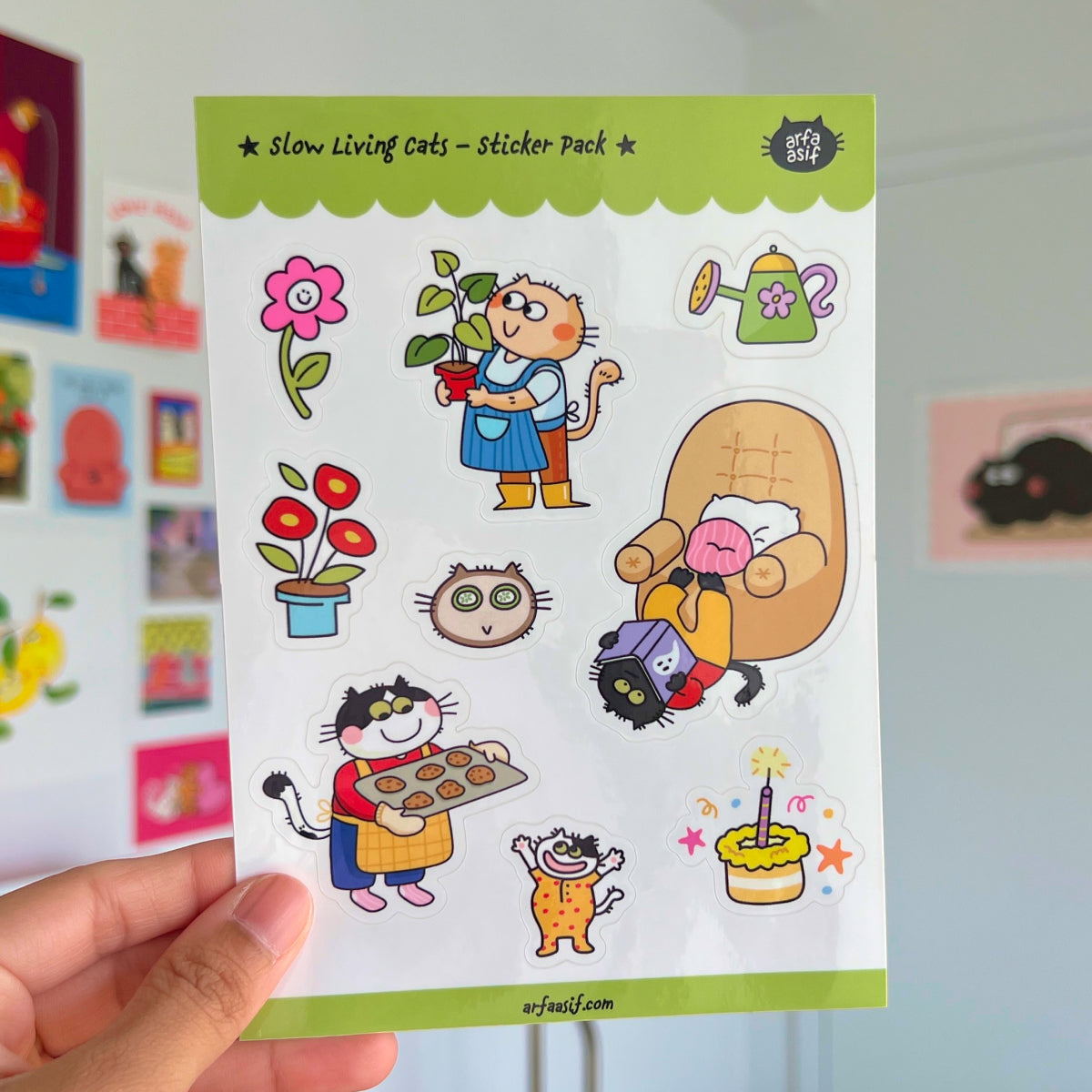 Sheet of fun cat stickers held by a hand with a colorful background.