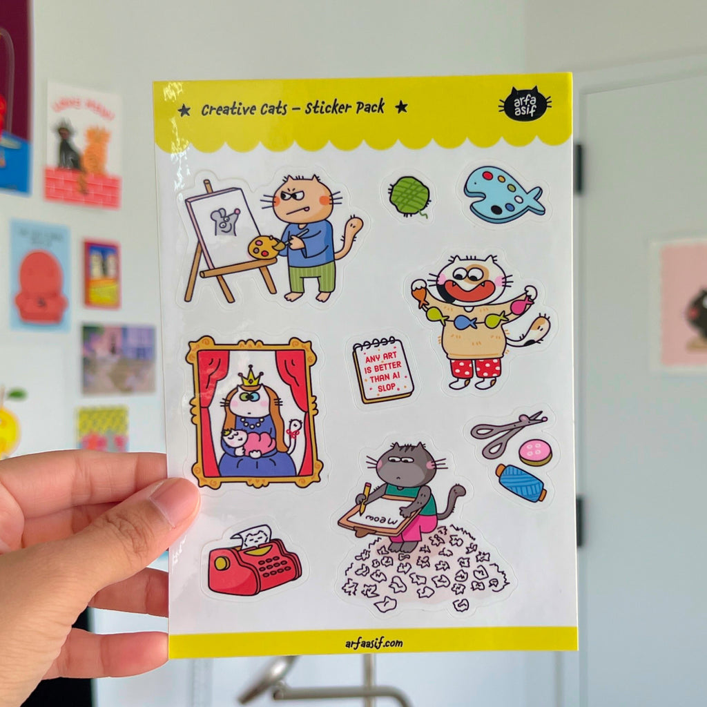Sheet of 'Creative Cats' stickers held by a hand with a colorful background.