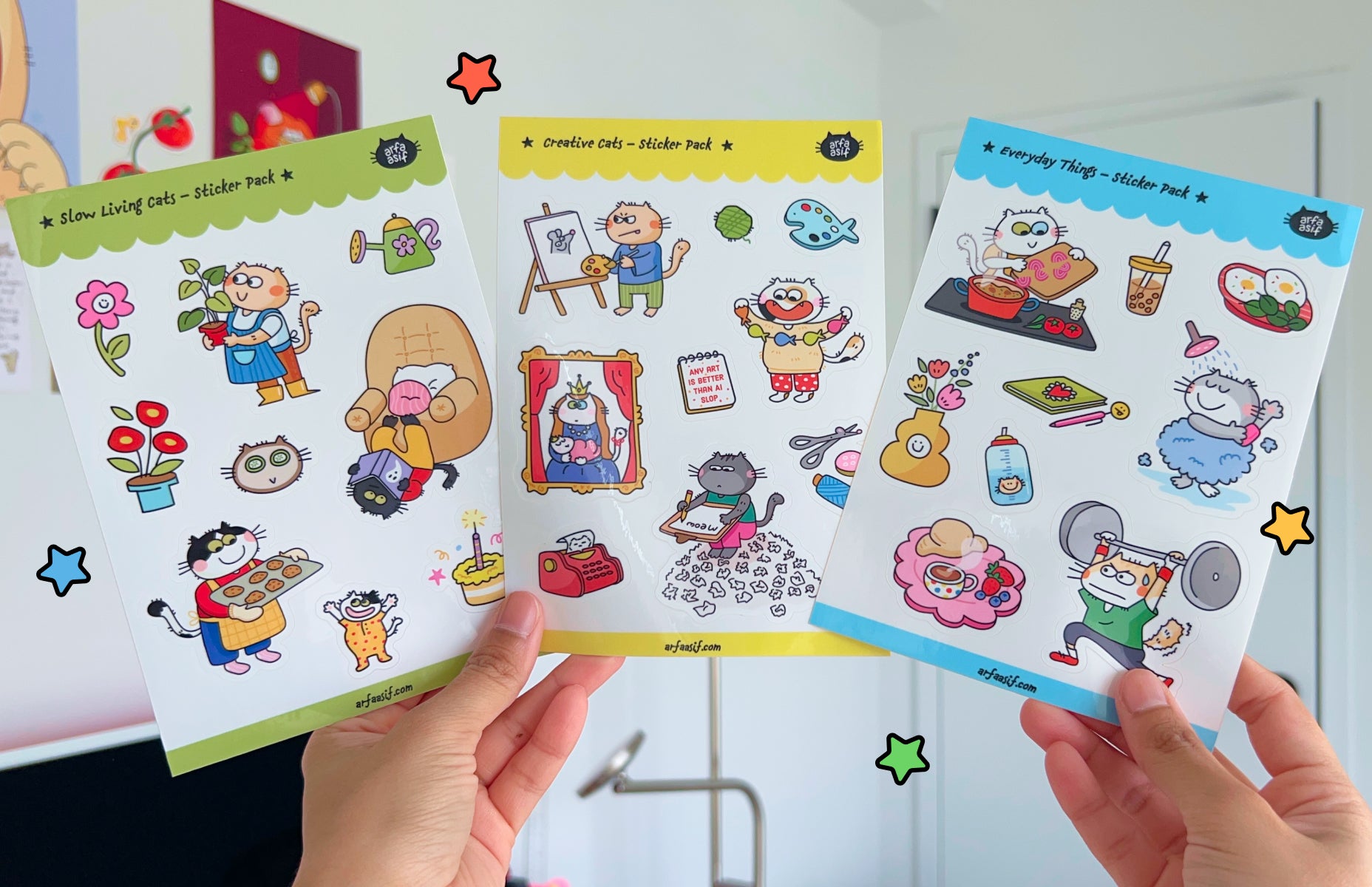 Three cat sticker sheets held by hands with a colorful background