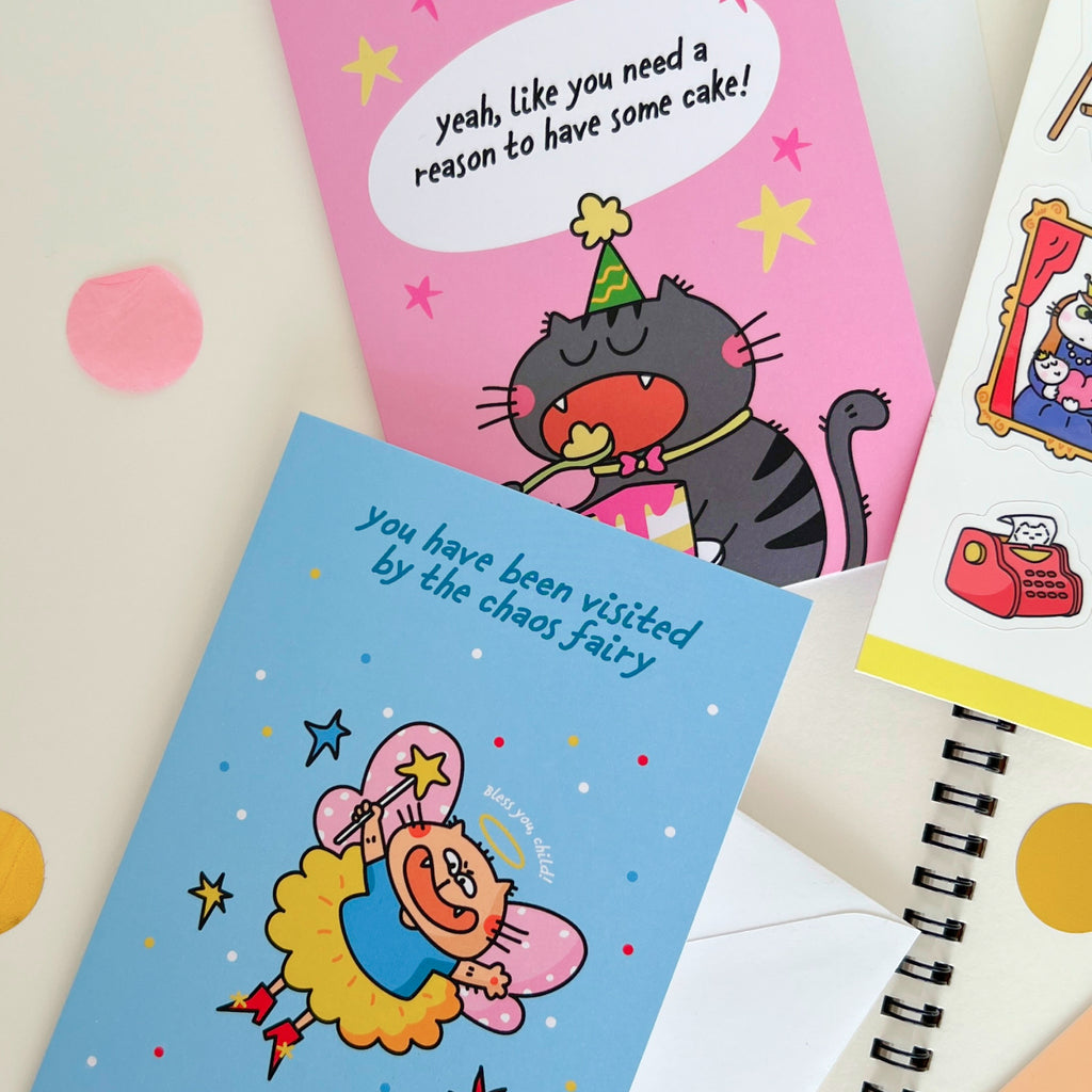 Two colorful cat greeting cards on a light background