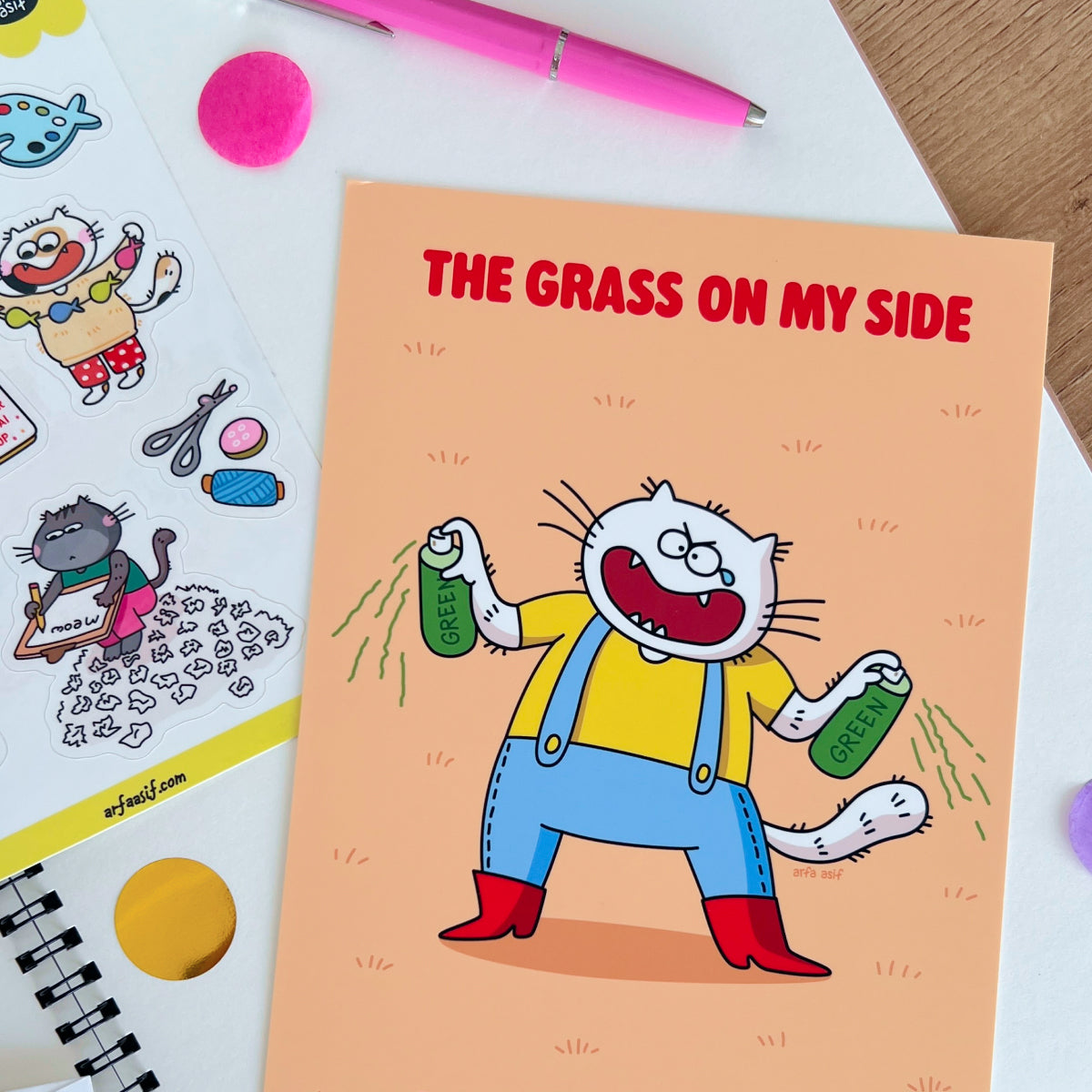 Art print with a funny cat character and text 'The Grass on My Side' on a colorful background.