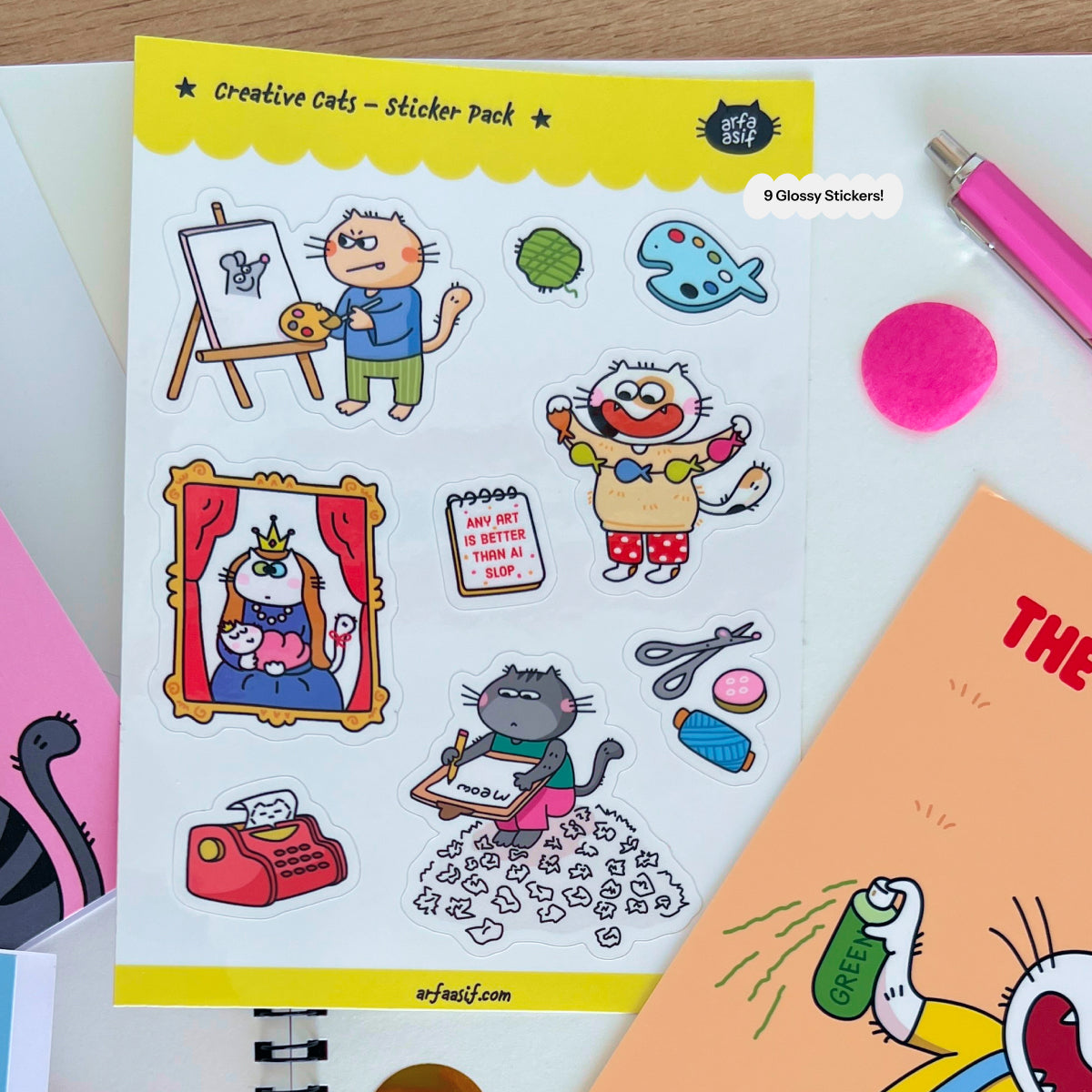 Sticker pack with fun cats on a white surface with stationery items.