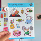 Sticker pack with cat illustrations held by a hand against a colorful background