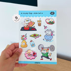 Hand holding a sticker pack with cat illustrations on a light background