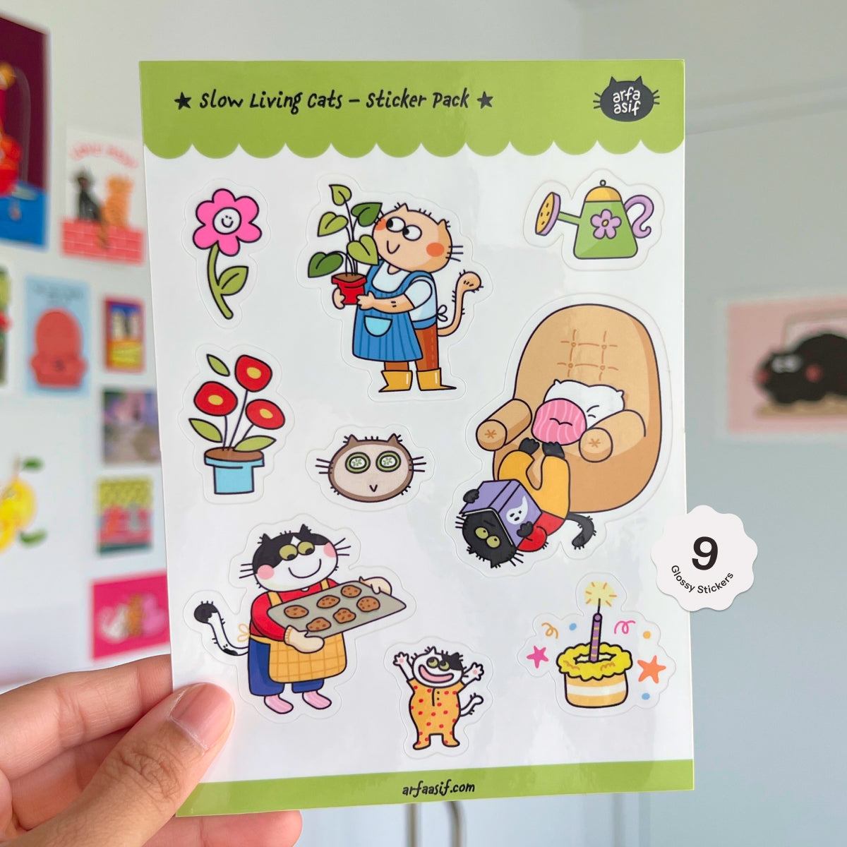 Sticker pack with cats and related items held by a hand.